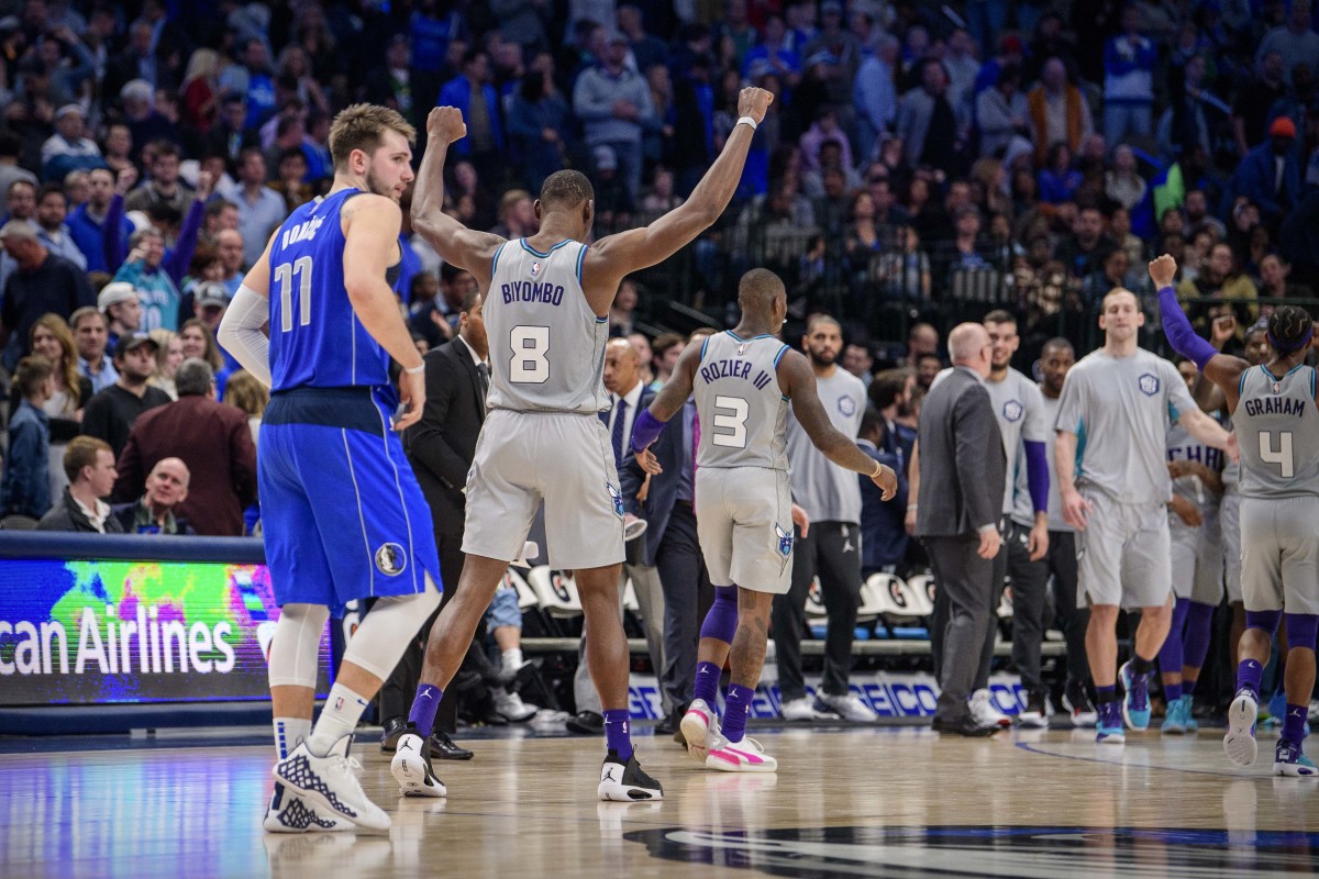 Jan 4, 2020; Dallas, Texas, USA; Charlotte Hornets center Bismack Biyombo (8) celebrates the win as Dallas Mavericks forward Luka Doncic (77) walks off the court after the game at the American Airlines Center. Mandatory Credit: Jerome Miron-USA TODAY Sports