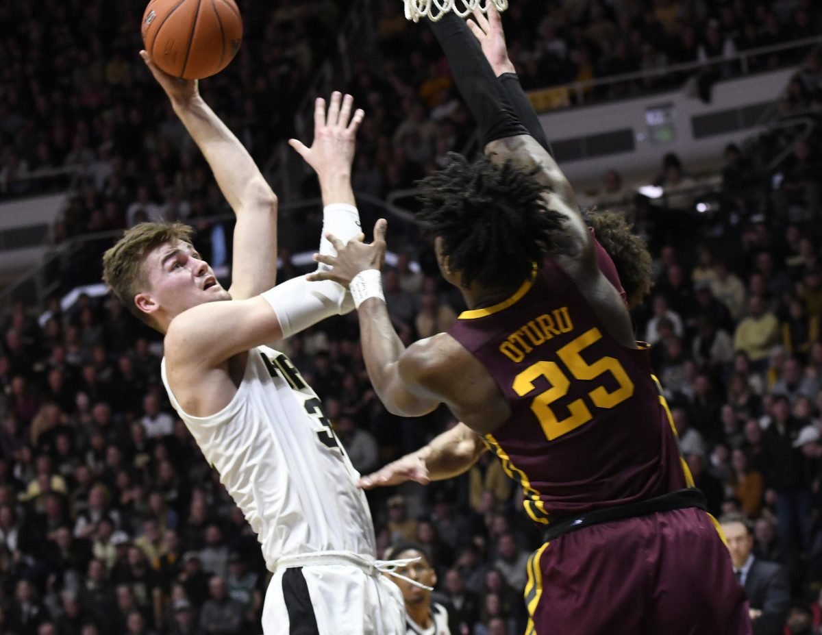 Purdue Boilermakers center Matt Haarms (32) loft the ball over the outstretched arm of Minnesota Golden Gophers center Daniel Oturu (25) in the first half at Mackey Arena.