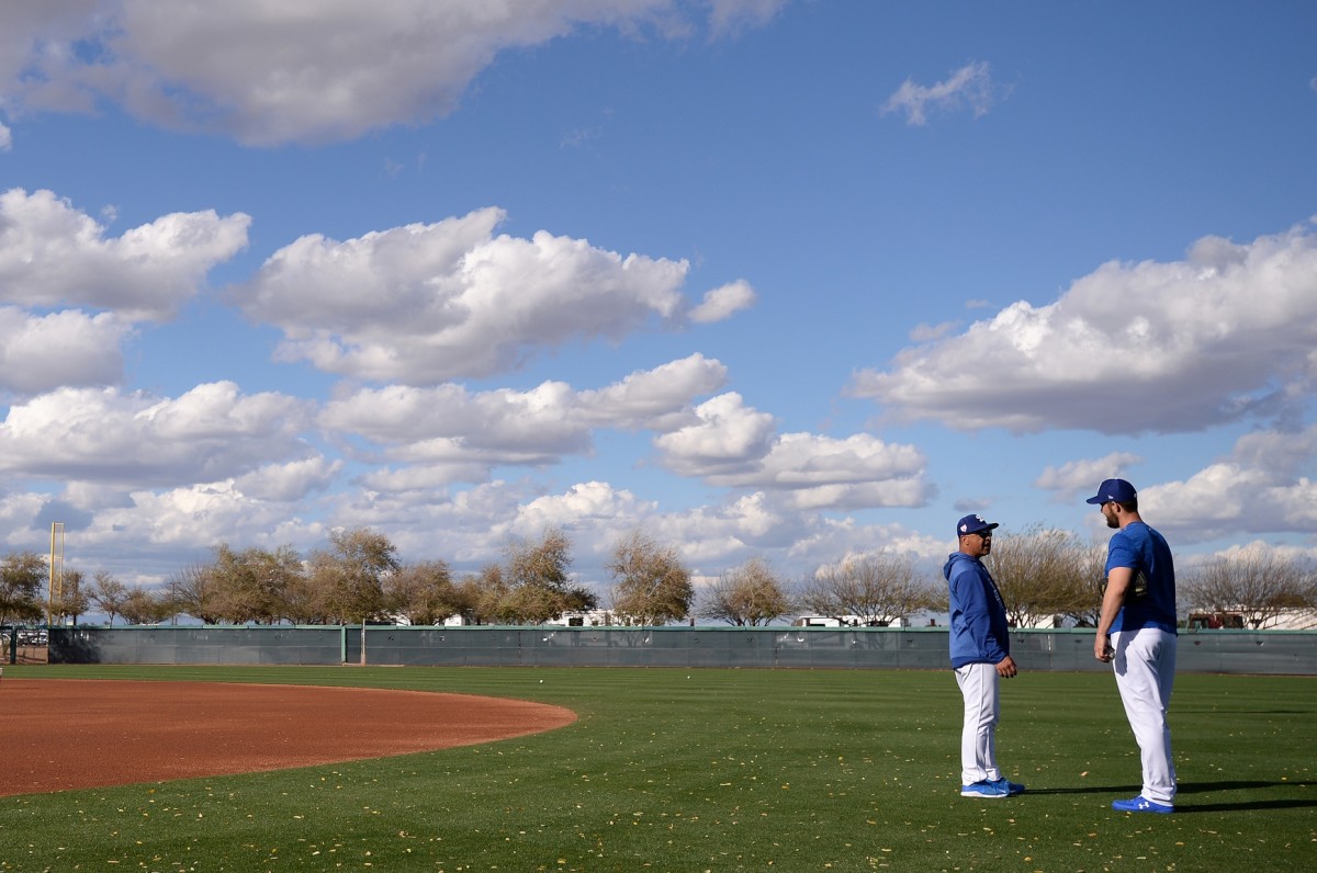 Mar 8, 2019; Phoenix, AZ, USA; Los Angeles Dodgers manager Dave Roberts (left) and starting pitcher Clayton Kershaw (right) talk during warmups before the game against the Kansas City Royals at Camelback Ranch. Mandatory Credit: Orlando Ramirez-USA TODAY Sports