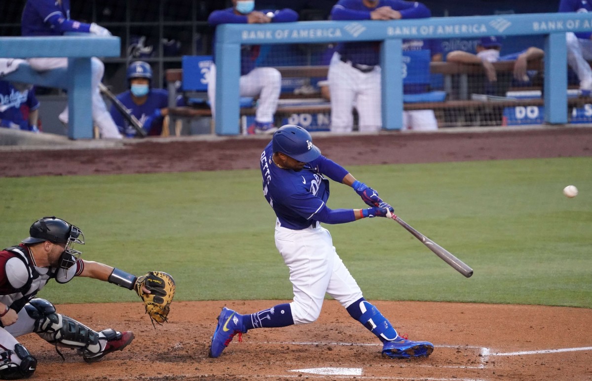 Jul 20, 2020; Los Angeles, California, USA; Los Angeles Dodgers right fielder Mookie Betts (50) follows through on a three-run home run in the second inning as Arizona Diamondbacks catcher Stephen Vogt (21) watches at Dodger Stadium. Mandatory Credit: Kirby Lee-USA TODAY Sports