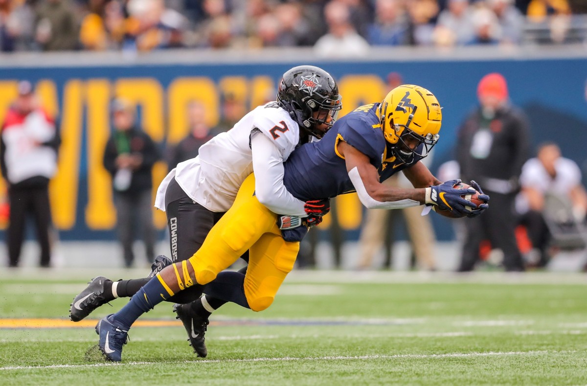 T.J. Simmons makes a catch against Oklahoma State and is tackled by Tanner McCalister last season.