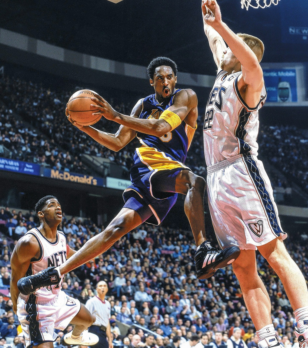 Kobe Bryant pushes the ball upcourt in a white Laker jersey.JPG
