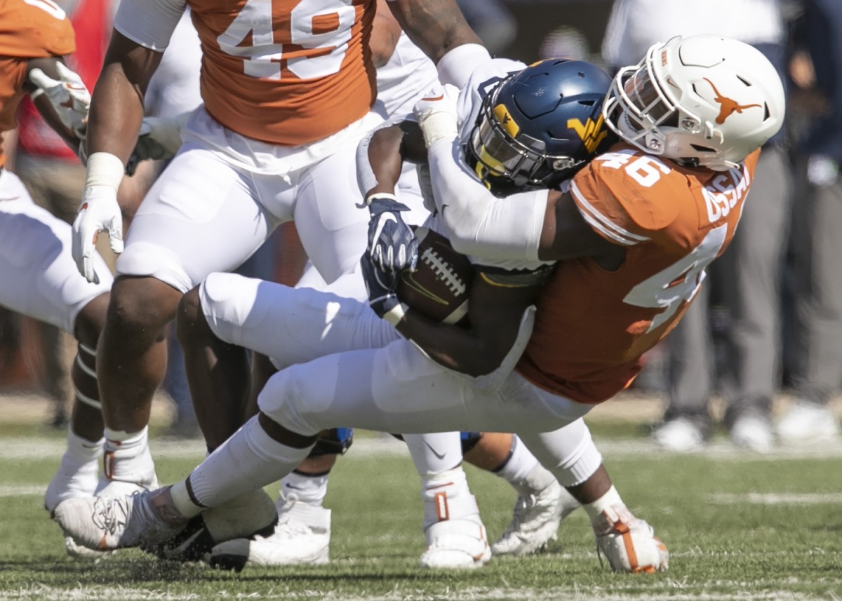 Texas linebacker Joseph Ossai tackles West Virginia running back Alec Sinkfield in the first quarter at Royal-Memorial Stadium on Saturday November 7, 2020.