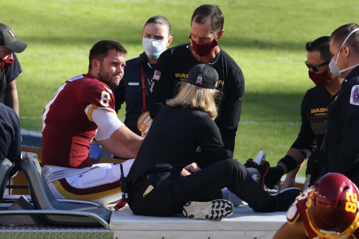 Nov 8, 2020; Landover, Maryland, USA; Washington Football Team quarterback Kyle Allen (8) sits on a cart after being injured by being tripped by New York Giants strong safety Jabrill Peppers (not pictured) while scrambling in the first quarter at FedExField.