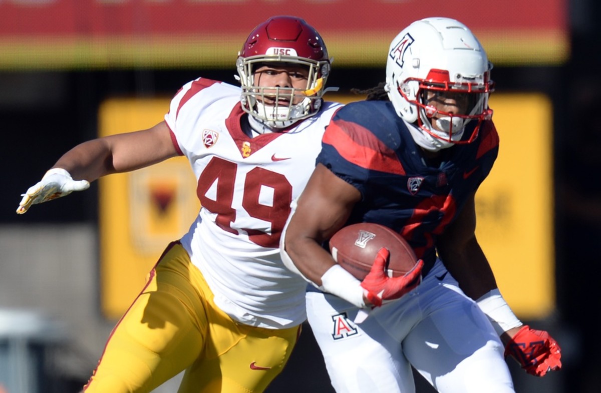 Nov 14, 2020; Tucson, Arizona, USA; USC Trojans defensive lineman Tuli Tuipulotu (49) pursues Arizona Wildcats running back Gary Brightwell (0) during the first half at Arizona Stadium.