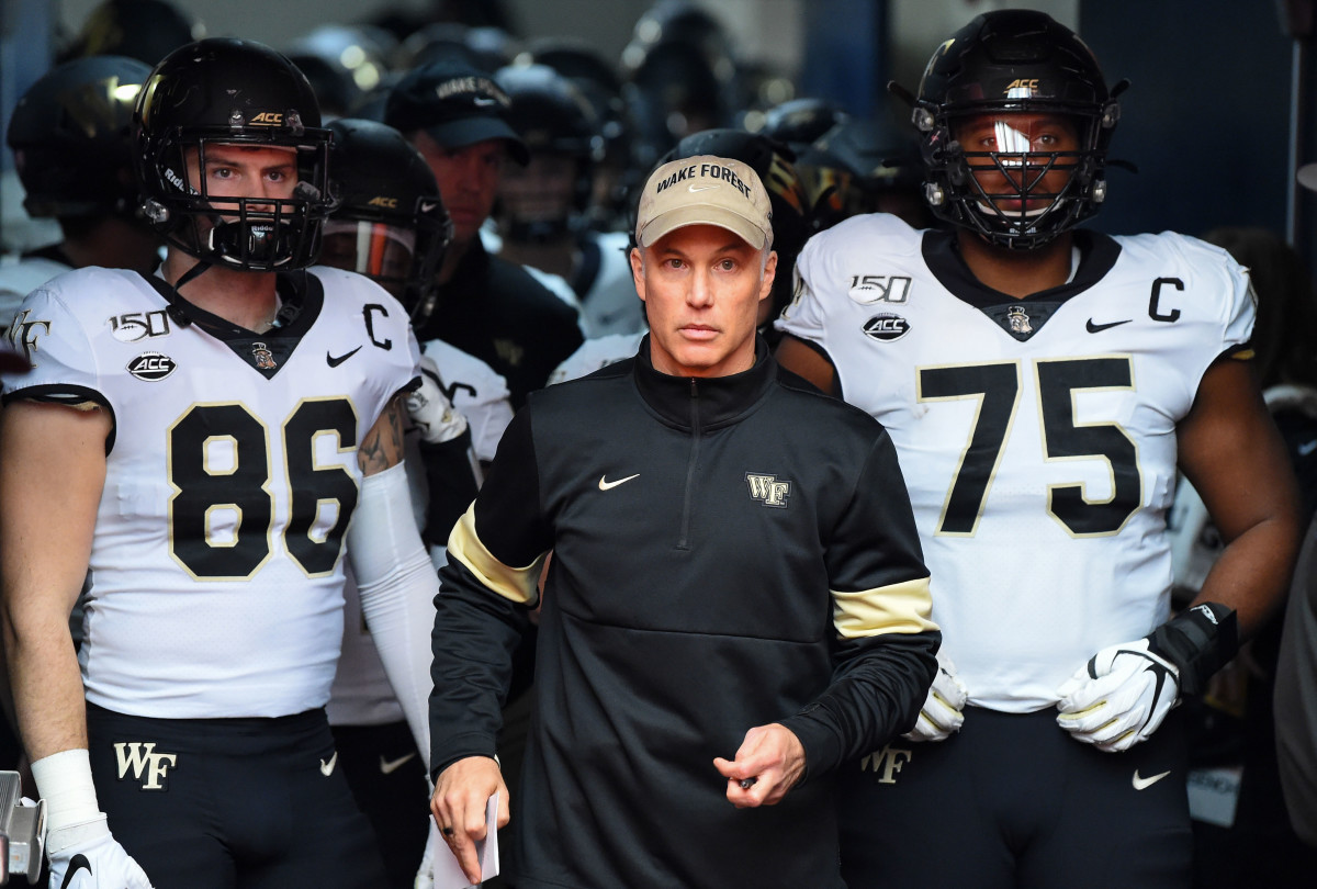 Wake Forest Demon Deacons head coach Dave Clawson stands with tight end Jack Freudenthal (86) and offensive lineman Justin Herron (75) prior to taking the field for a 2019 game against the Syracuse Orange at the Carrier Dome.