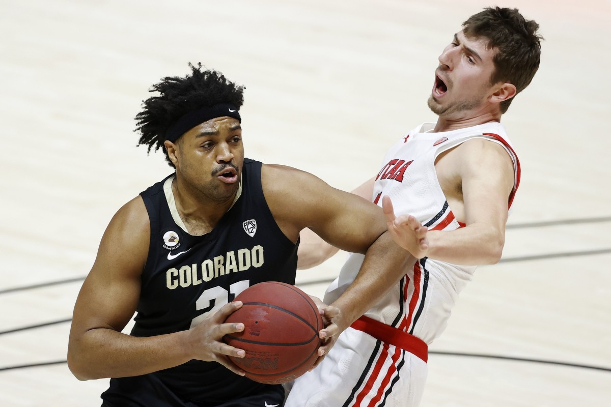 Jan 11, 2021; Salt Lake City, Utah, USA; Colorado Buffaloes forward Evan Battey (21) drives against Utah Utes forward Riley Battin (21) in the first half at Jon M. Huntsman Center.