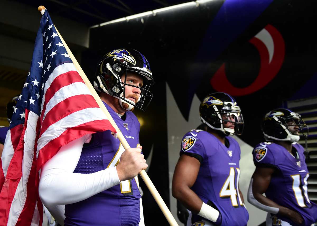 Baltimore Ravens long snapper Morgan Cox (46) waits to take the field while  holding a flag as part of the team's Salute to Service prior to an NFL  football game against the