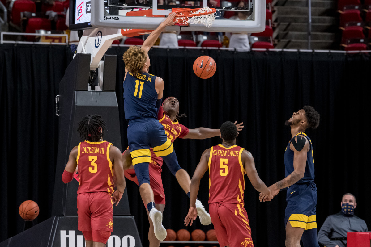 West Virginia forward Emmitt Matthews Jr. (11) dunks over Iowa State forward Solomon Young to put the Mountaineers up 59-46 with just over 12 minutes to play in the game.