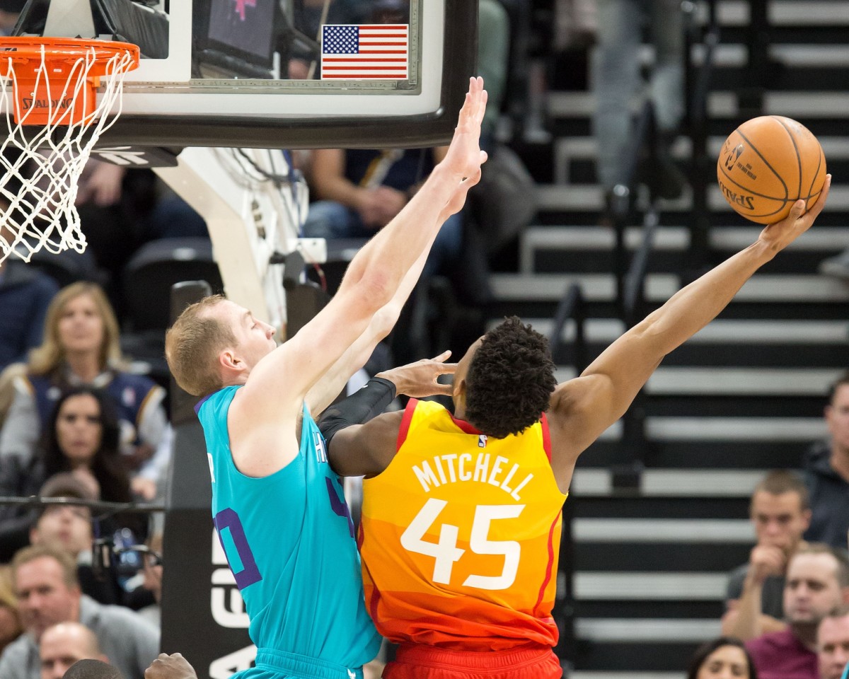 Donovan Mitchell (45) tries a hook shot over Cody Zeller (40)