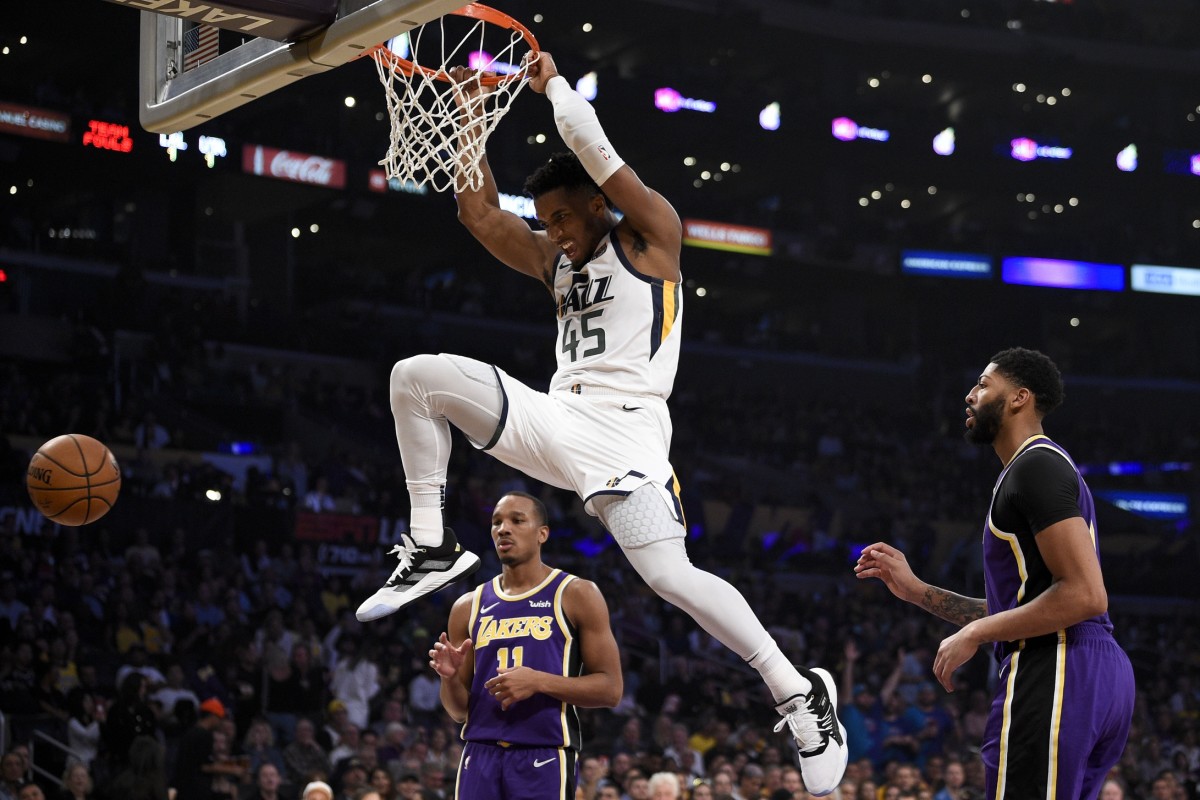 Donovan Mitchell (45) dunks over Anthony Davis (3) and Avery Bradley (11)