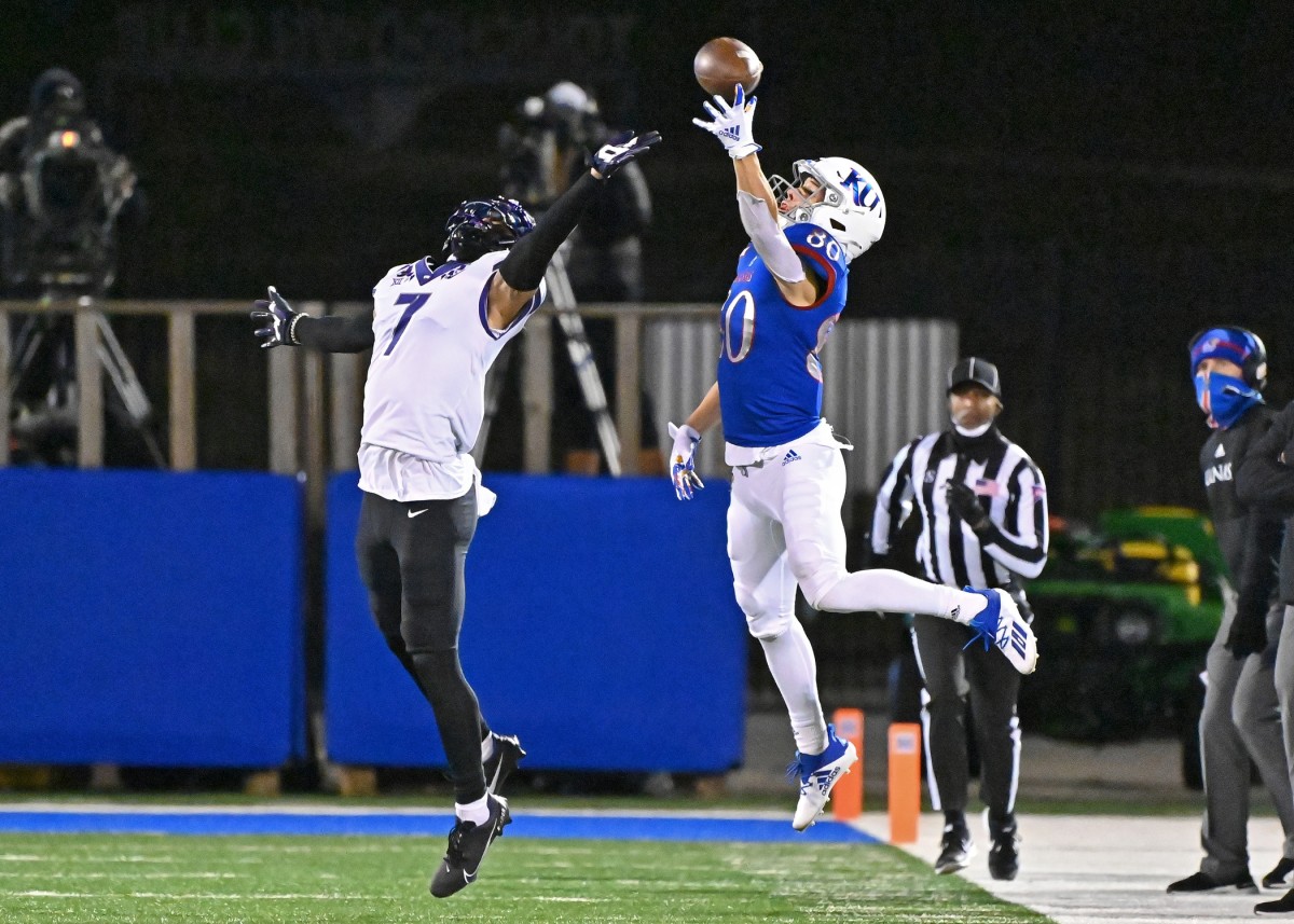 Kansas wide receiver Luke Grimm (80) goes up for a pass against TCU Horned Frogs safety Trevon Moehrig (7). Mandatory Credit: Peter Aiken-USA TODAY Sports