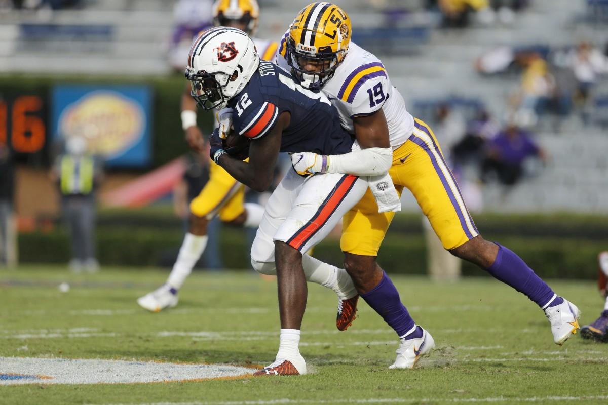 Oct 31, 2020; Auburn, Alabama, USA; Auburn receiver Eli Stove (12) is tackled by LSU linebacker Jabril Cox (21). Mandatory Credit: John Reed-USA TODAY Sports