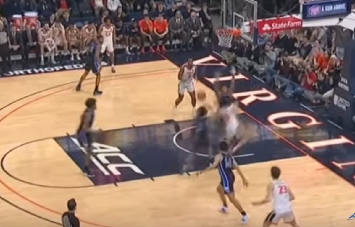 Clark (the blur to the right of the charge circle) passes around Moore (hands up). That's Vernon Carey, at the ACC logo on the foul line. 