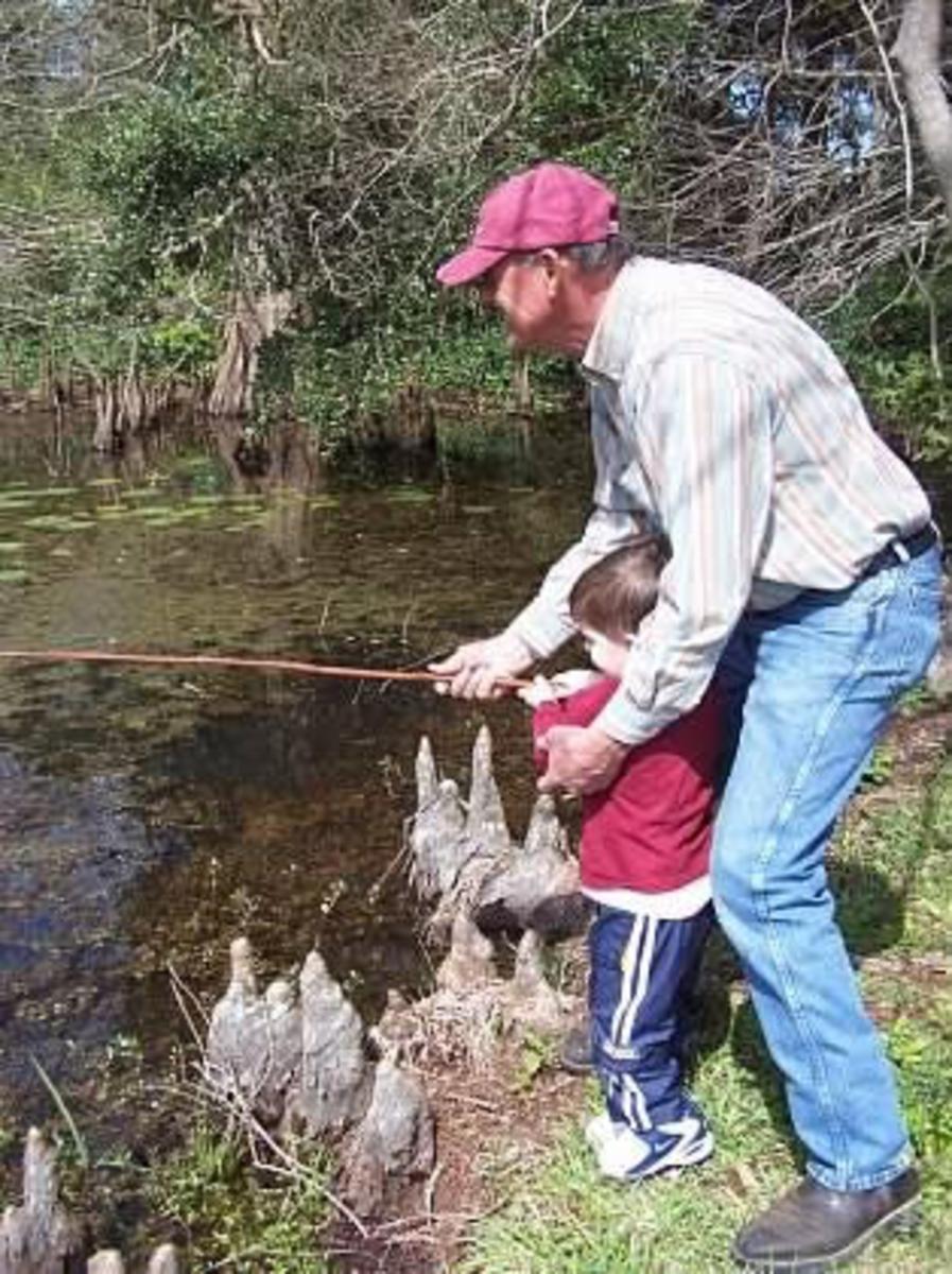 [Paul Hebert teaches his grandson, Garrett Nussmeier, how to fish]