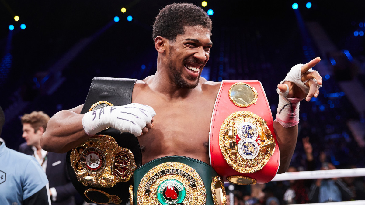 Boxer Anthony Joshua poses with his heavyweight championship belts after defeating Andy Ruiz in Saudi Arabia.