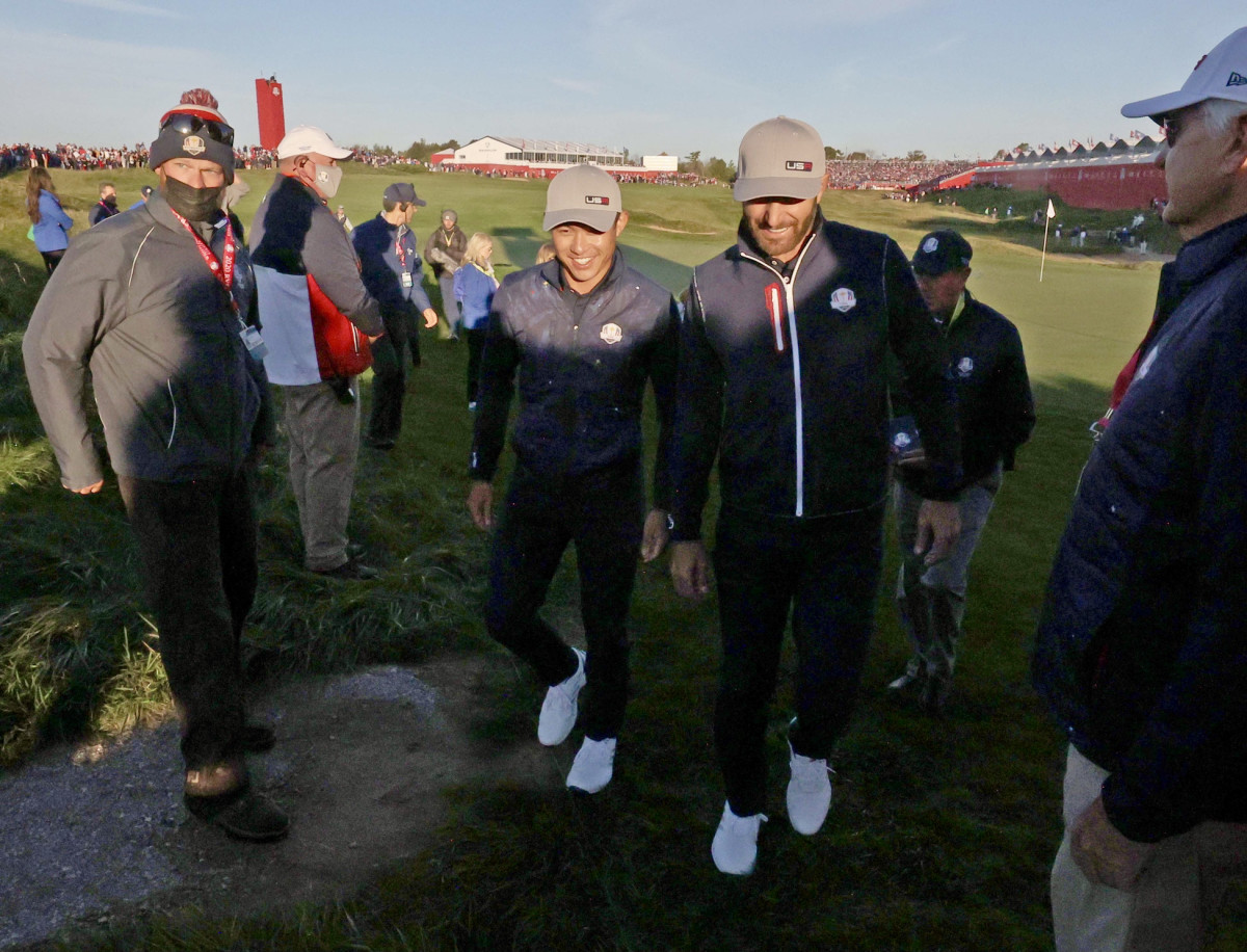 Collin Morikawa and Dustin Johnson walk toward the second tee.