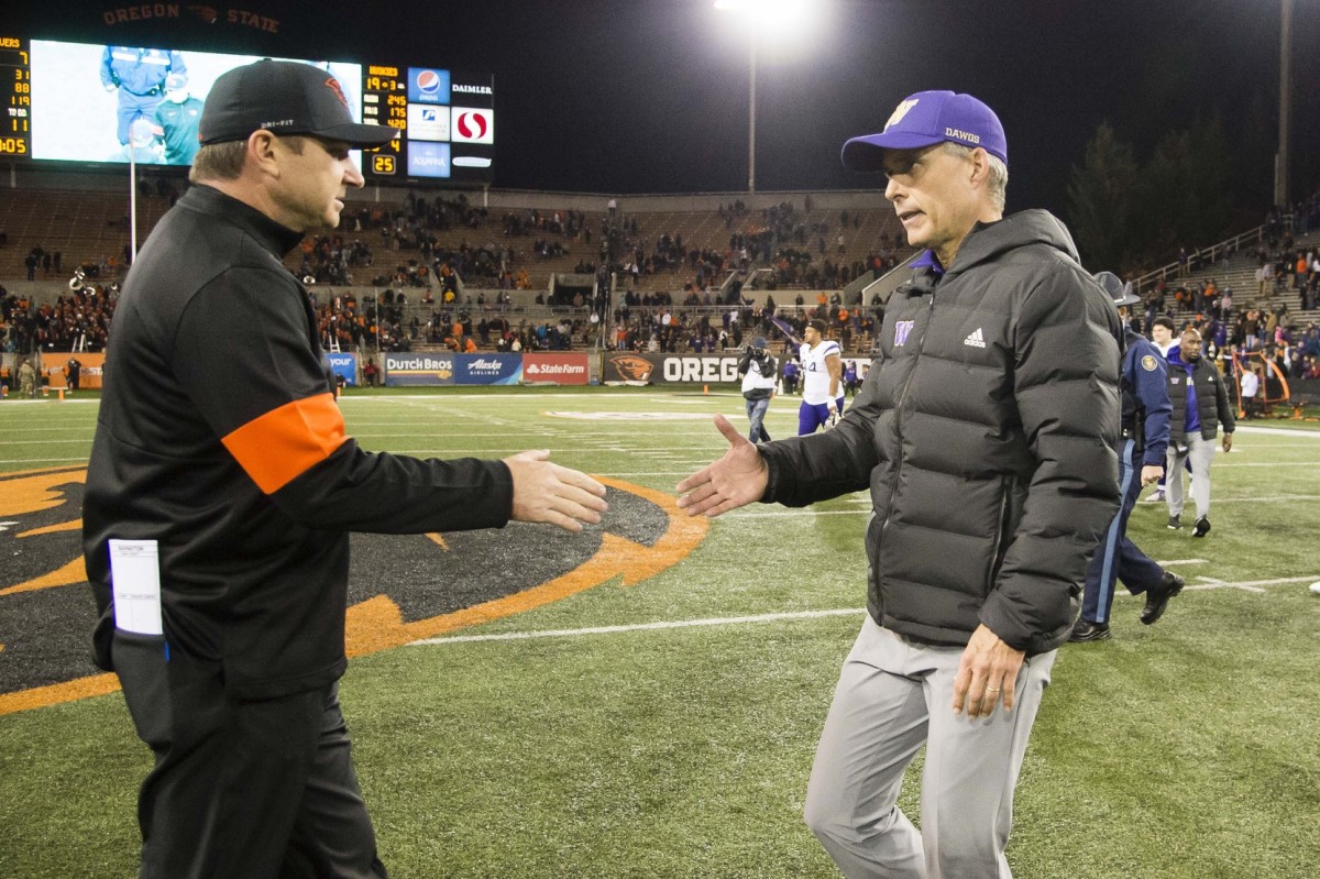 Jonathan Smith shakes hands with Chris Petersen after the OSU-UW game in Corvallis in 2019.