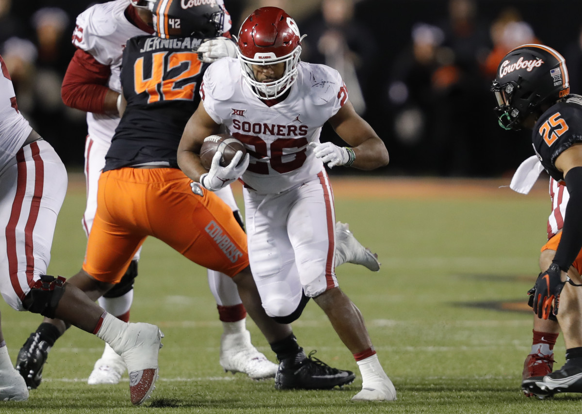 Nov 27, 2021; Stillwater, Oklahoma, USA; Oklahoma Sooners running back Kennedy Brooks (26) runs for a first down against the Oklahoma State Cowboys during the second half at Boone Pickens Stadium. Oklahoma State won 37-33.