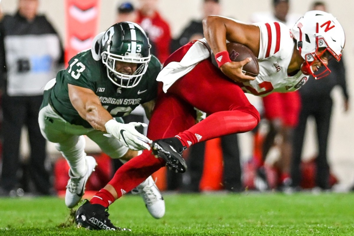 Adrian Martinez tries to break a Michigan State tackle.