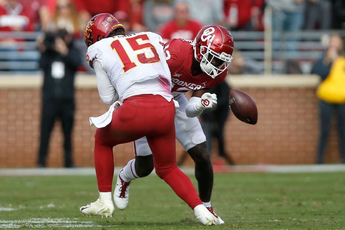 Oklahoma's Key Lawrence (12) forces a fumble as he hits Iowa State's Brock Purdy (15).