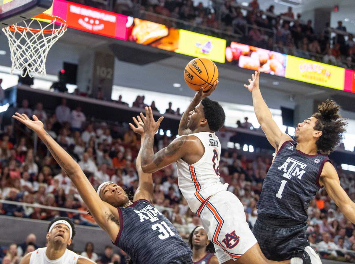 Auburn Tigers guard K.D. Johnson (0) goes up for a layup over Texas A&M Aggies forward Javonte Brown (31) as Auburn Tigers men's basketball takes on Texas A&M Aggies at Auburn Arena in Auburn, Ala., on Saturday, Feb. 12, 2022. Auburn Tigers lead Texas A&M Aggies 33-18 at halftime.