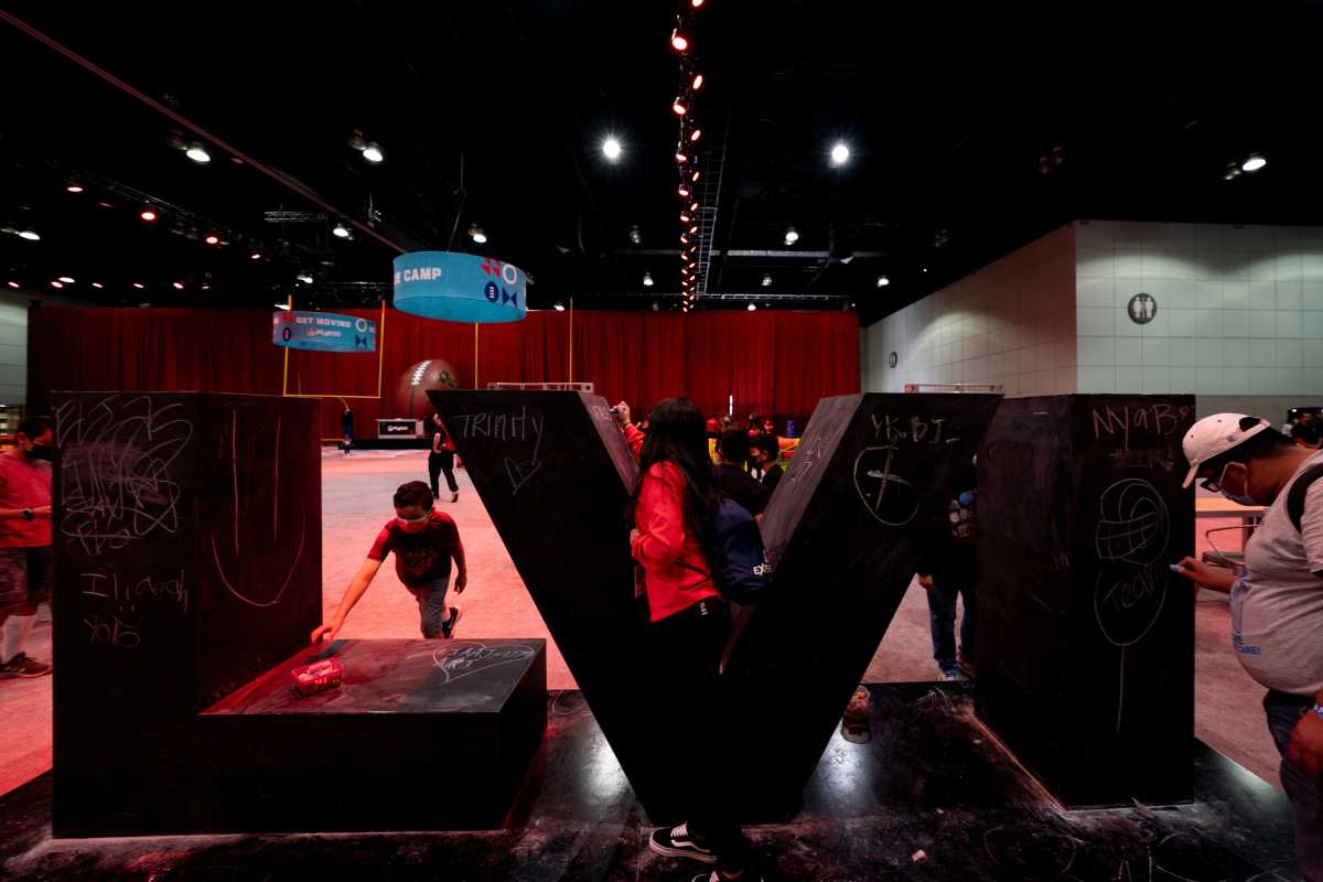 Lucas Recinos, 10, of San Diego, Calif., grabs chalk to sign the Super Bowl symbol at the Super Bowl Experience presented by Lowe's Friday, Feb. 11, 2022, at the LA Convention Center in Las Angeles, Calif.