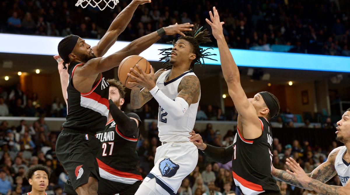 Memphis Grizzlies guard Ja Morant (12) shoots against Portland Trail Blazers forward Justise Winslow (26) and guard Josh Hart (11) in the second half of an NBA basketball game Wednesday, Feb. 16, 2022, in Memphis, Tenn.