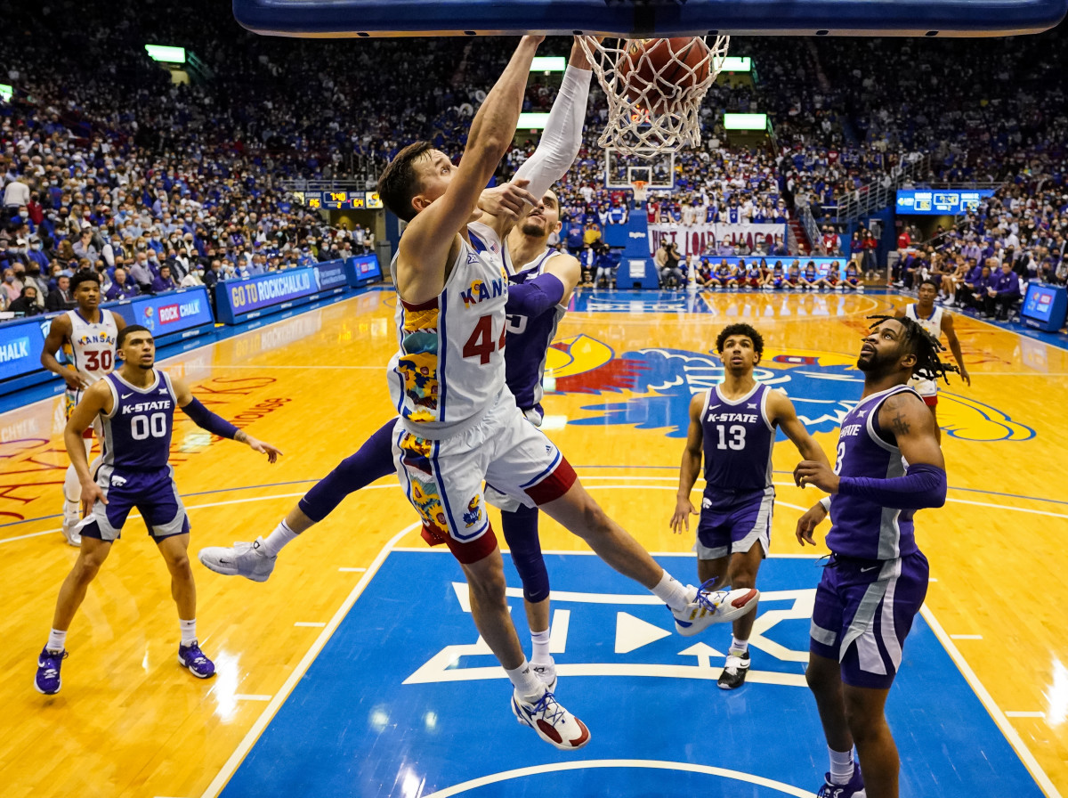 Feb 22, 2022; Lawrence, Kansas, USA; Kansas Jayhawks forward Mitch Lightfoot (44) dunks the ball as Kansas State Wildcats forward Ismael Massoud (25) defends during the second half at Allen Fieldhouse.