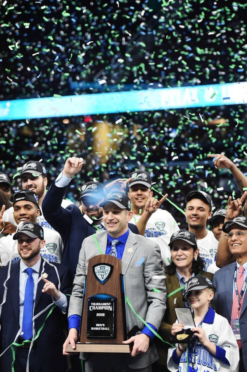 Buffalo Bulls head coach Nate Oates holds the championship trophy after the Bulls beat the Toledo Rockets in the Mid-American Conference Championship game at Quicken Loans Arena.