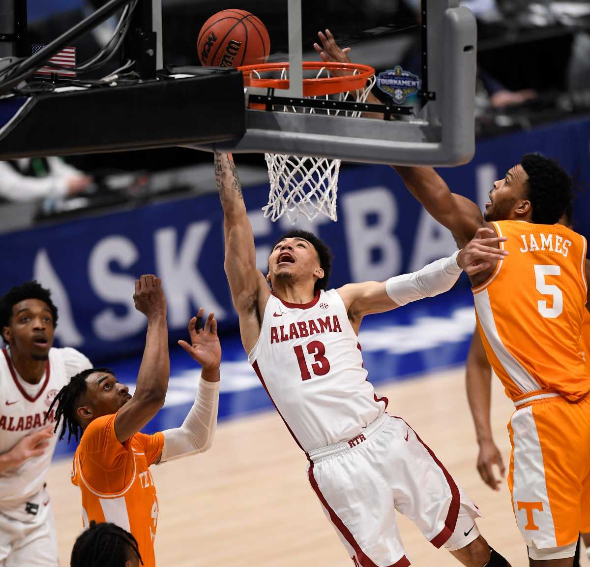 Alabama guard Jahvon Quinerly (13) shoots past Tennessee guard Keon Johnson (45) and guard Josiah-Jordan James (5) during the second half of the SEC Men's Basketball Tournament semifinal game at Bridgestone Arena