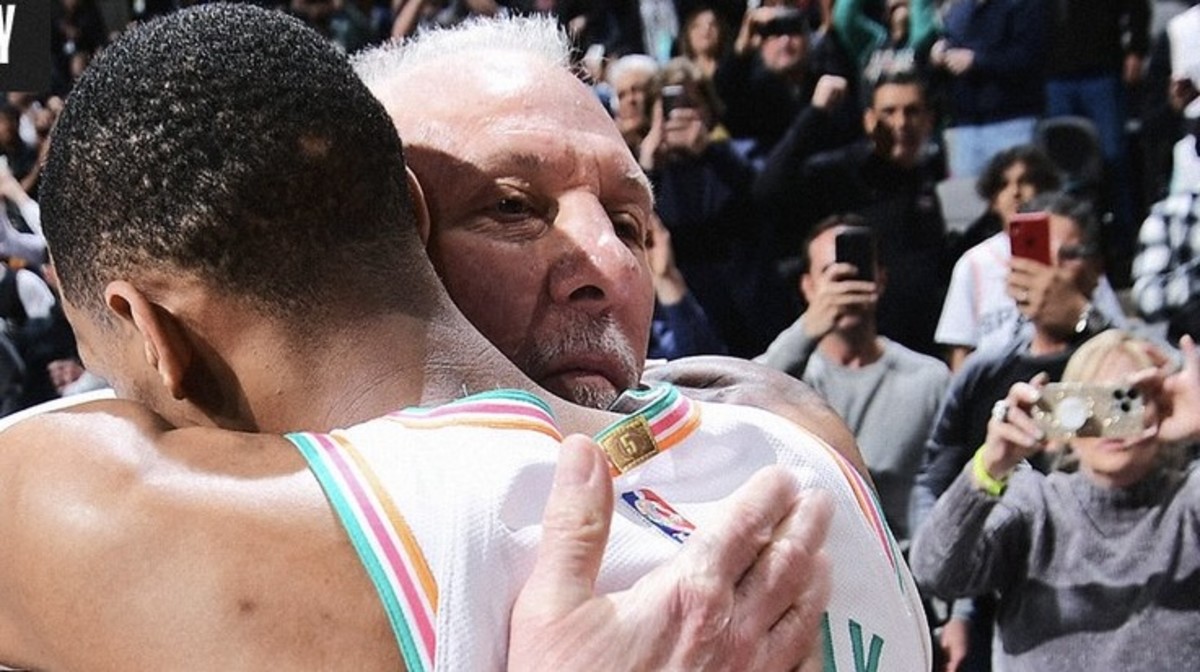 Dejounte Murray and Gregg Popovich embrace after the latter became the NBA's all-time winningest coach.