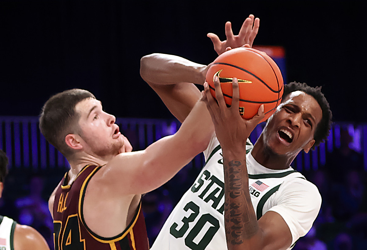 Michigan State Spartans forward Marcus Bingham Jr. (30) and Loyola Ramblers guard Tate Hall (24) go for the ball during the second half of the 2021 Battle 4 Atlantis Tournament at Imperial Arena.