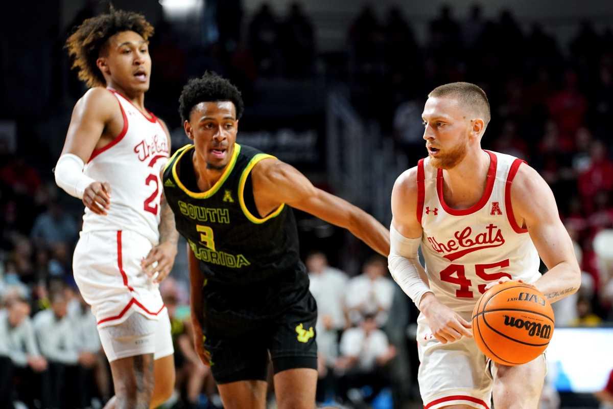 Cincinnati Bearcats guard Mason Madsen (45) drives past South Florida Bulls forward DJ Patrick (3) in the second half of a men's NCAA basketball game, Saturday, Feb. 26, 2022, at Fifth Third Arena in Cincinnati. The South Florida Bulls won, 54-52. South Florida Bulls At Cincinnati Bearcats Basketball 077