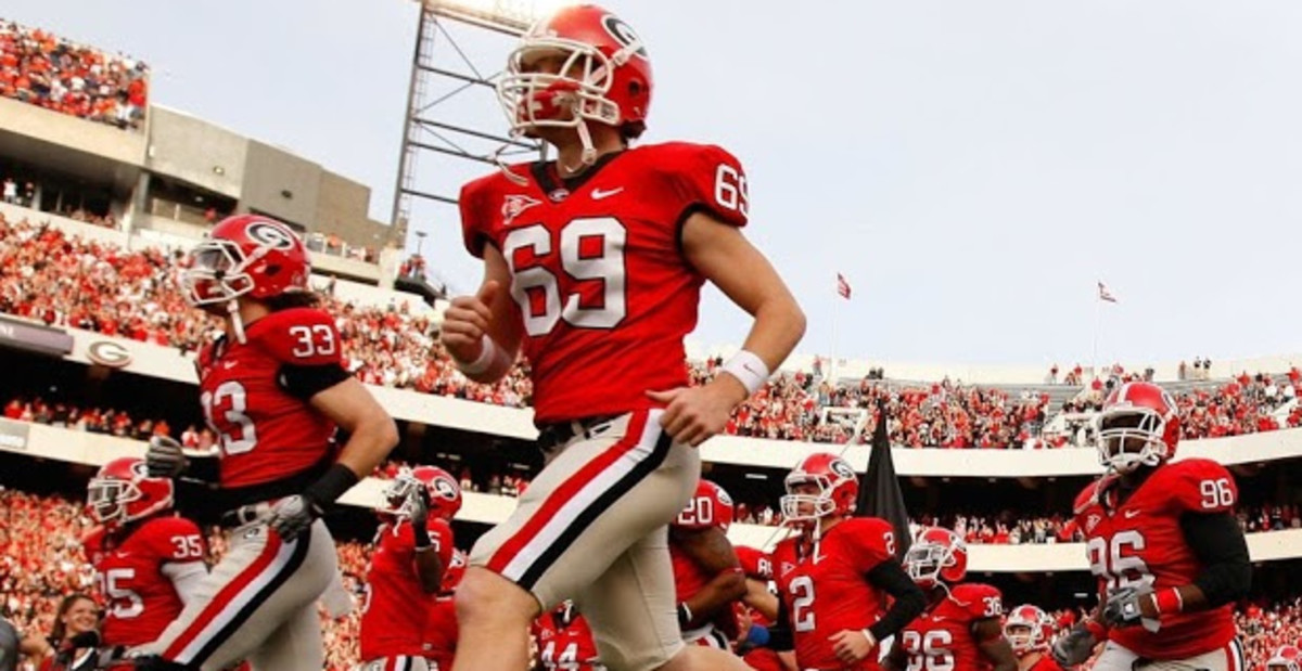 Georgia Bulldogs players run onto the field ahead of a college football game in the SEC.