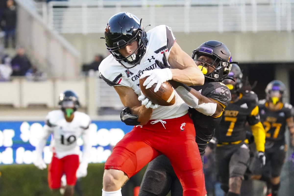 Nov 26, 2021; Greenville, North Carolina, USA; Cincinnati Bearcats wide receiver Alec Pierce (12) makes a catch behind East Carolina Pirates cornerback Ja'Quan McMillian (21) during the first half at Dowdy-Ficklen Stadium. Mandatory Credit: James Guillory-USA TODAY Sports