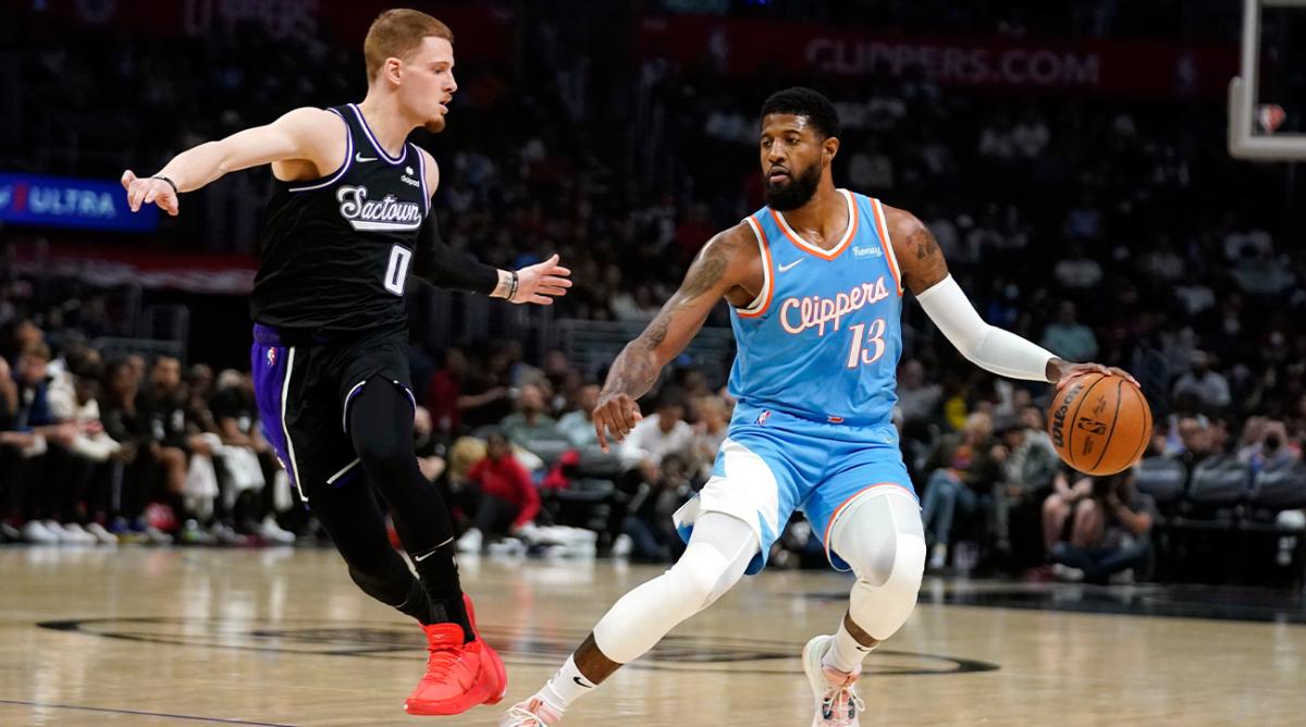 Los Angeles Clippers guard Paul George (13) is defended by Sacramento Kings guard Donte DiVincenzo (0) during the first half of an NBA basketball game Saturday, April 9, 2022, in Los Angeles.
