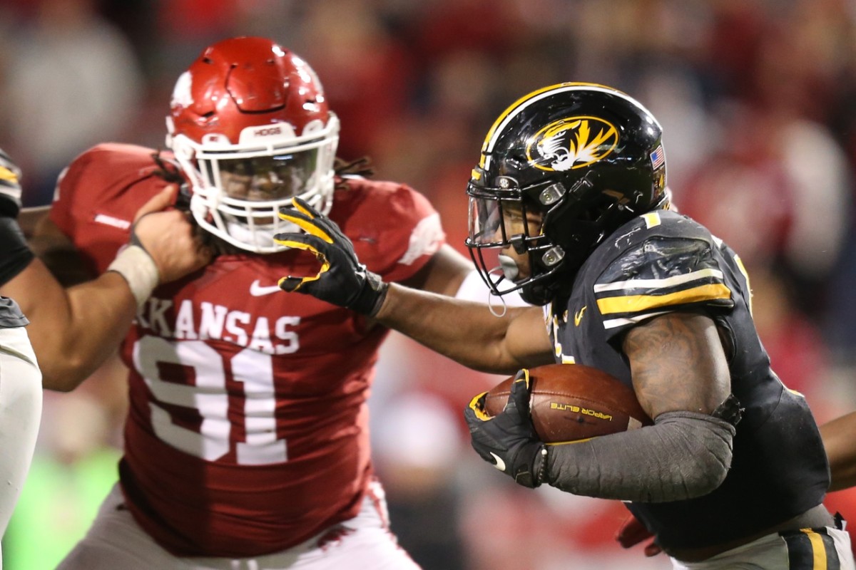 Nov 26, 2021; Fayetteville, Arkansas, USA; Missouri Tigers running back Tyler Badie (1) runs the ball as Arkansas Razorbacks defensive lineman Taurean Carter (91) defends in the second half at Donald W. Reynolds Razorbacks Stadium.