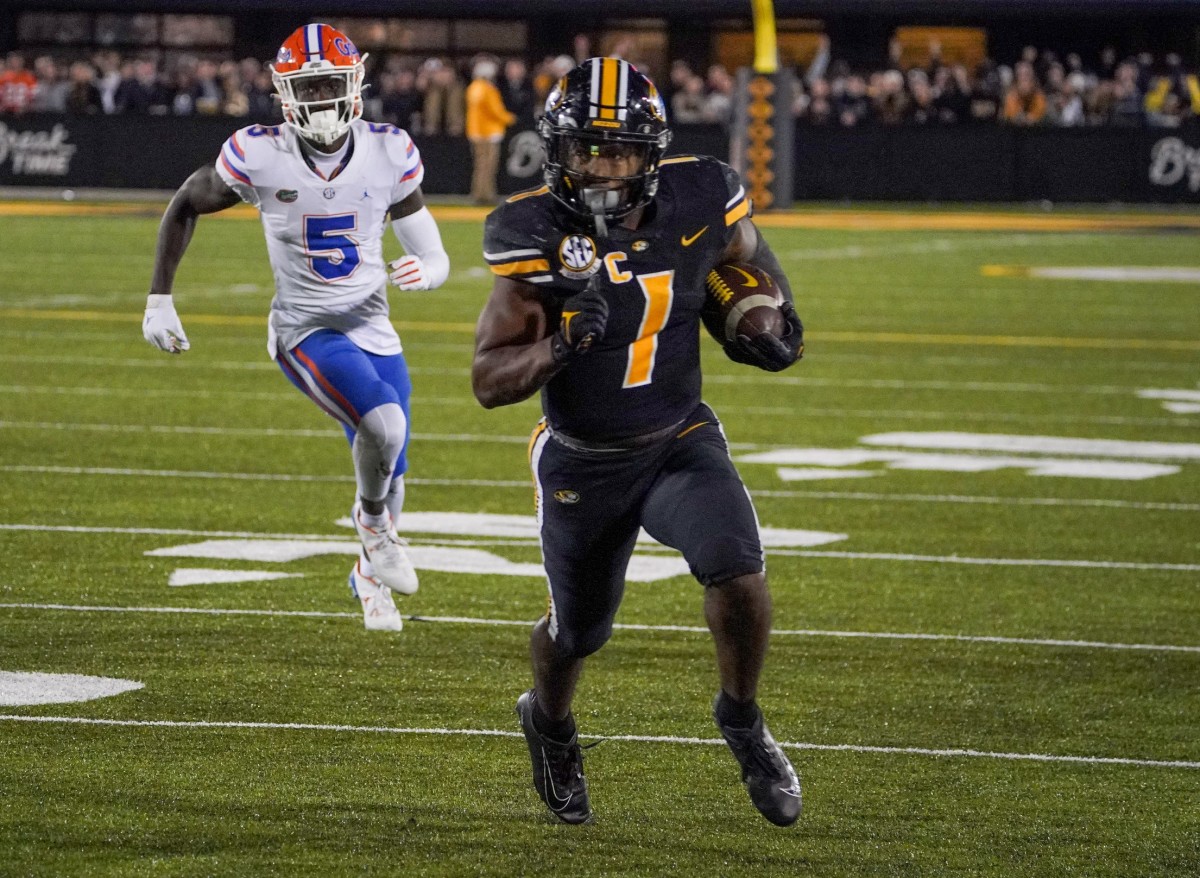 Nov 20, 2021; Columbia, Missouri, USA; Missouri Tigers running back Tyler Badie (1) runs the ball as Florida Gators cornerback Kaiir Elam (5) chases in overtime at Faurot Field at Memorial Stadium.