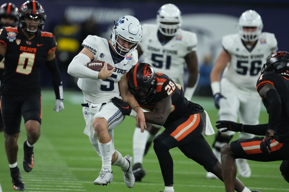 Utah State Aggies quarterback Cooper Legas (5) carries the ball against the Oregon State Beavers in the second half in the 2021 LA Bowl at SoFi Stadium.