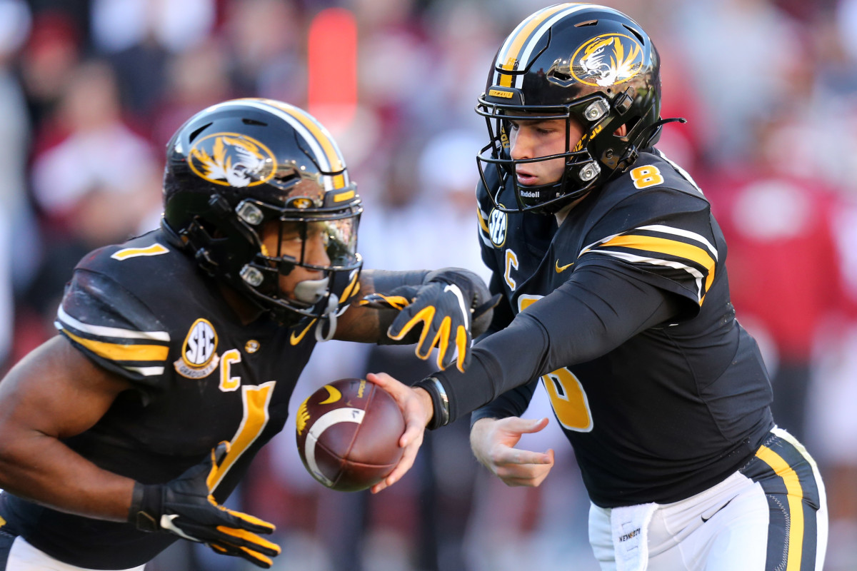 Nov 26, 2021; Fayetteville, Arkansas, USA; Missouri Tigers quarterback Connor Bazelak (8) hands the ball off to running back Tyler Badie (1) during the first quarter against the Arkansas Razorbacks at Donald W. Reynolds Razorbacks Stadium. Mandatory Credit: Nelson Chenault-USA TODAY Sports