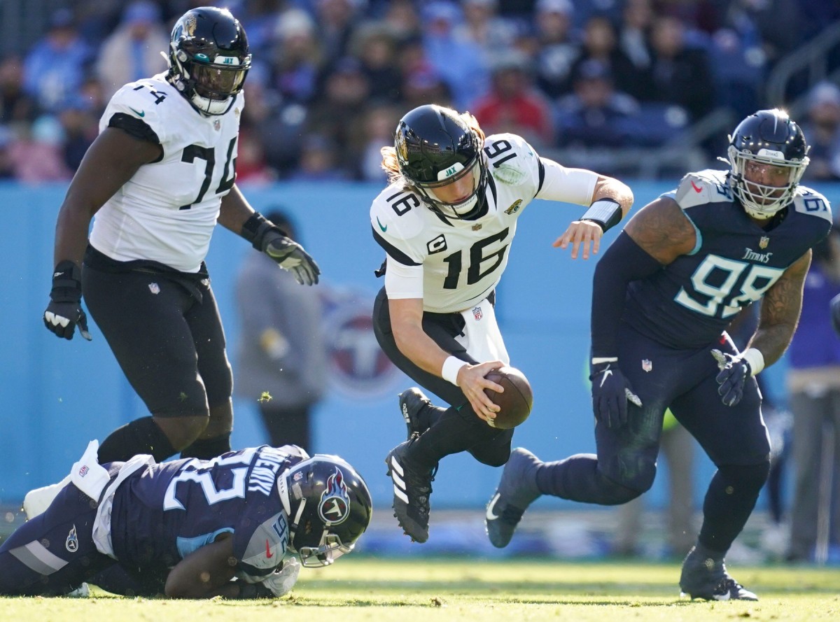 Tennessee Titans linebacker Ola Adeniyi (92) trips up Jacksonville Jaguars quarterback Trevor Lawrence (16) during the second quarter Nissan Stadium Sunday, Dec. 12, 2021 in Nashville, Tenn.