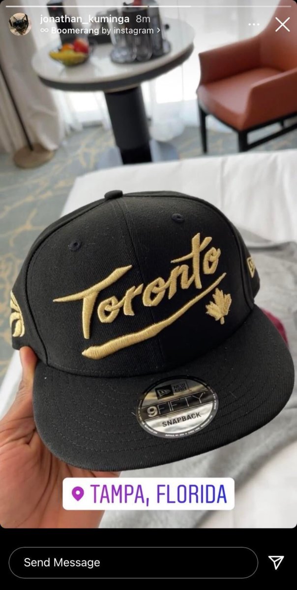 Jonathan Kuminga holding a Toronto Raptors hat