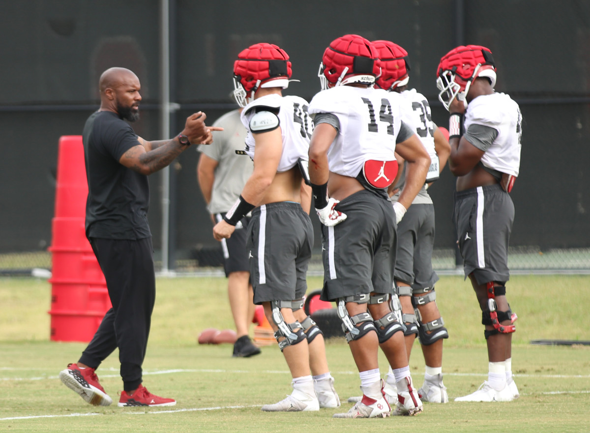 Jamar Cain coaching the OU defensive ends and outside linebackers, including Reggie Grimes (14)