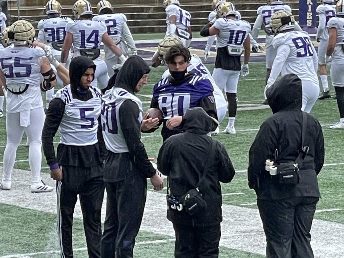 Asa Turner (20) watched the spring game will fellow injured Huskies Alex Cook (5) and Mason West (80).