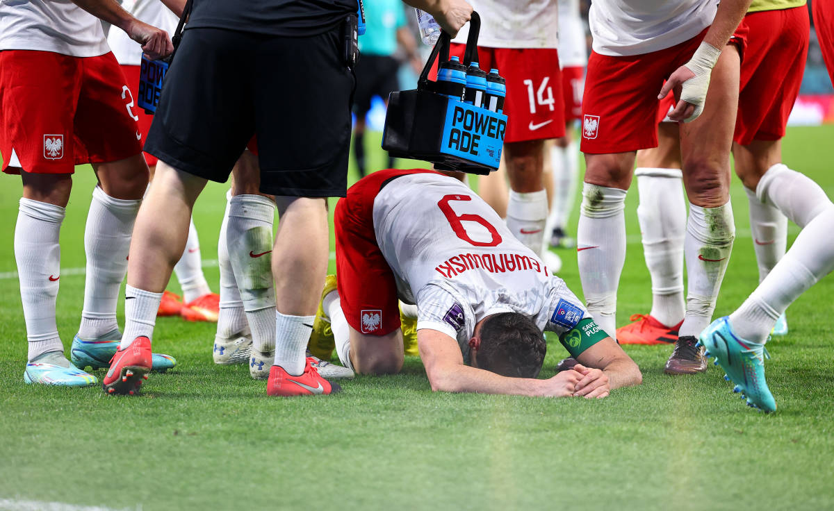 An emotional Robert Lewandowski pictured with his head on the ground after scoring the first goal of his World Cup career