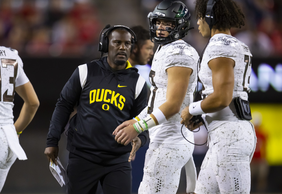 Oregon Ducks wide receivers coach and co-offensive coordinator Junior Adams with Bo Nix and Ty Thompson during a game against the Arizona Wildcats.