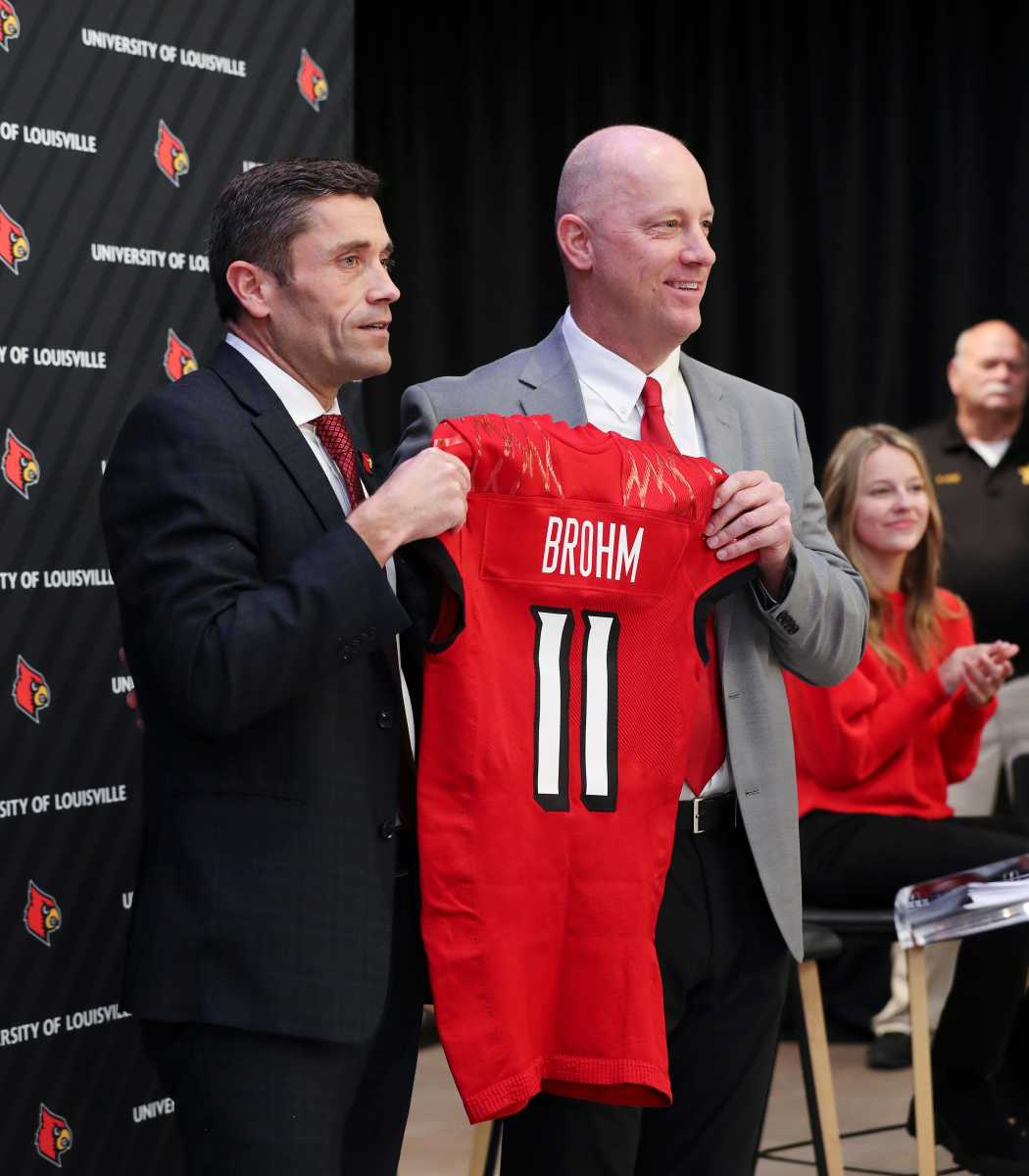 U of L Athletic Director Josh Heird, left, presented Jeff Brohm with a jersey after he was announced as the new head football coach at Cardinal Stadium in Louisville, Ky. on Dec. 8, 2022. Brohm08 Sam