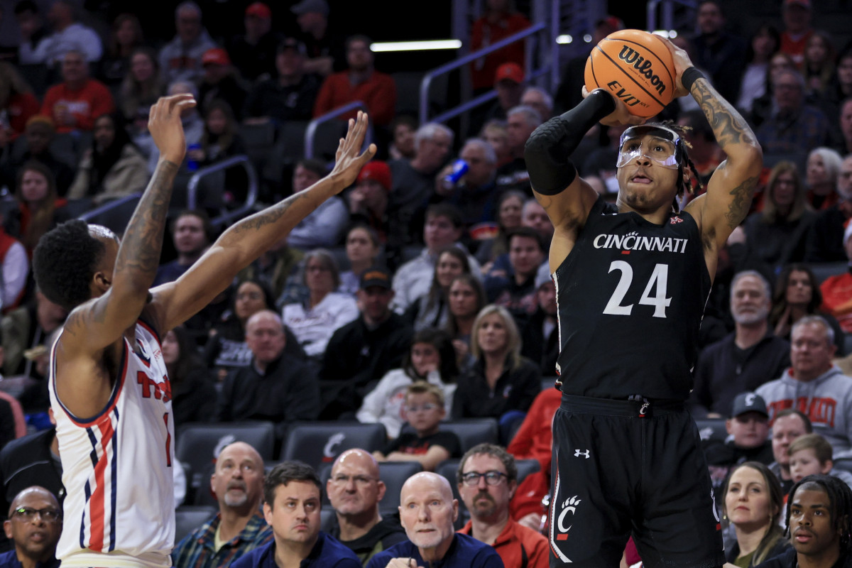 Dec 21, 2022; Cincinnati, Ohio, USA; Detroit Mercy Titans guard T.J. Moss, left, defends as Cincinnati Bearcats guard Jeremiah Davenport (24) attempts a three-point basket in the first half at Fifth Third Arena. Mandatory Credit: Aaron Doster-USA TODAY Sports