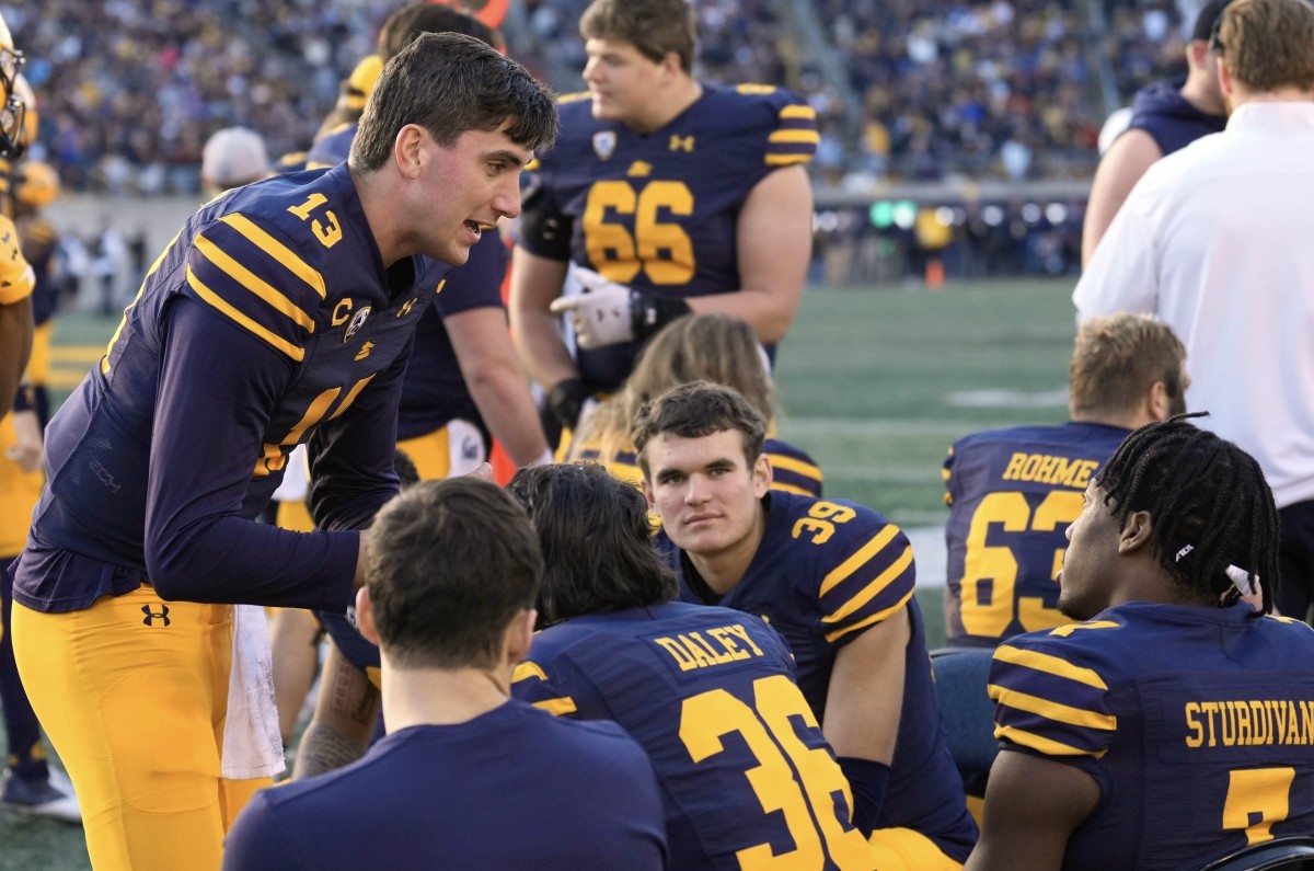 Quarterback Jack Plummer talks with teammates